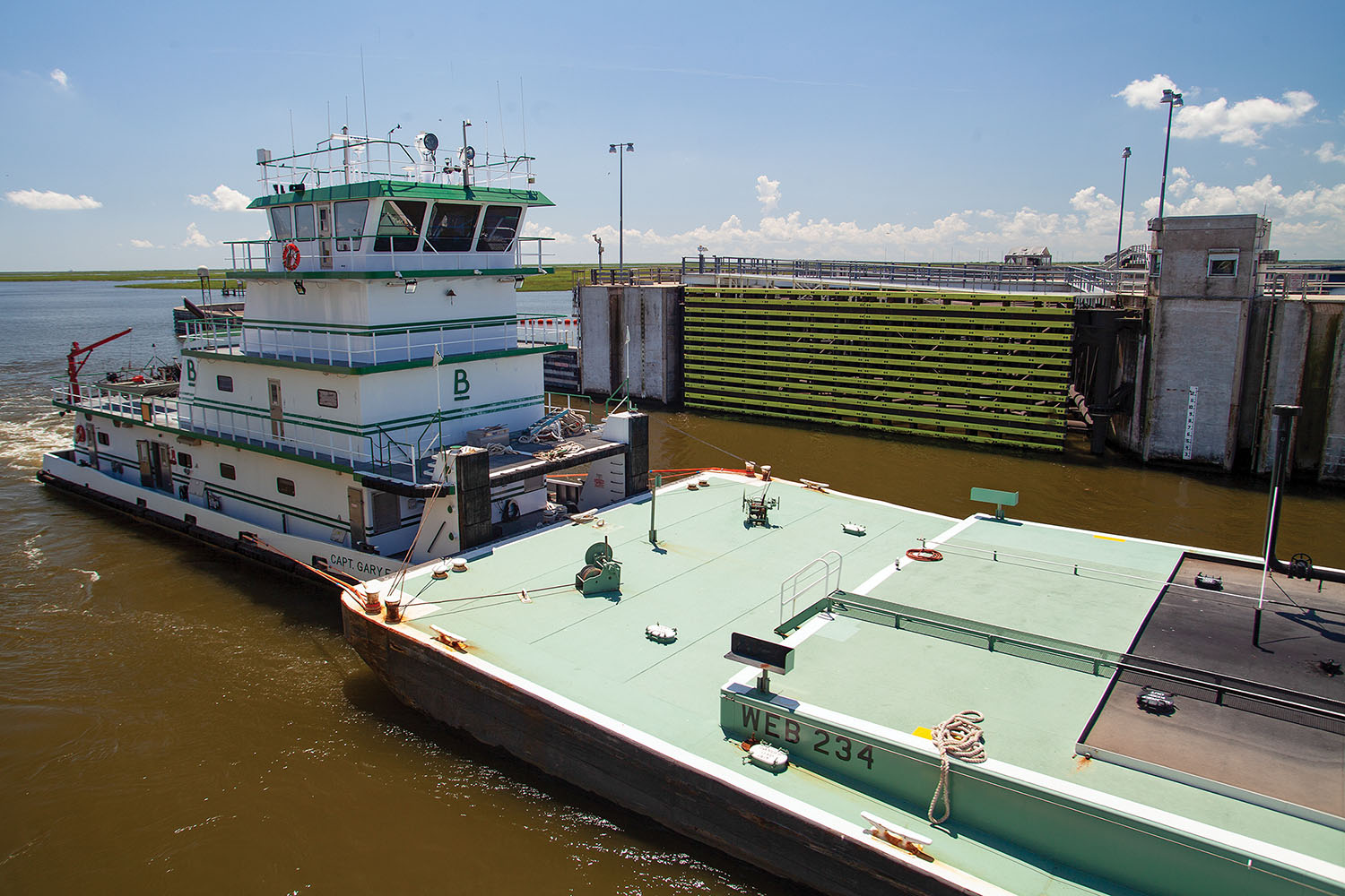 —photo by Frank McCormack Blessey Marine Service’s mv. Capt. Gary E. Moss pushes a pair of tank barges westbound through the Lake Borgne Surge Barrier June 2. (Photo by Frank McCormack)
