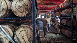 Scott Beyer (right) and two teammates stand aboard an O.H. Ingram River Aged floating barrelhouse in Columbus, Ky. (Photo by Frank McCormack)