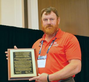 Capt. Charles F. Ashley Jr. holds the plaque honoring the safety record of the Dredge Jadwin at the WEDA Summit and Expo in Tampa in June. (Photo by Judith Powers)