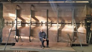 Ray Bergeron sits in front of a Cable Arm clamshell bucket. (Photo courtesy of Ray Bergeron)