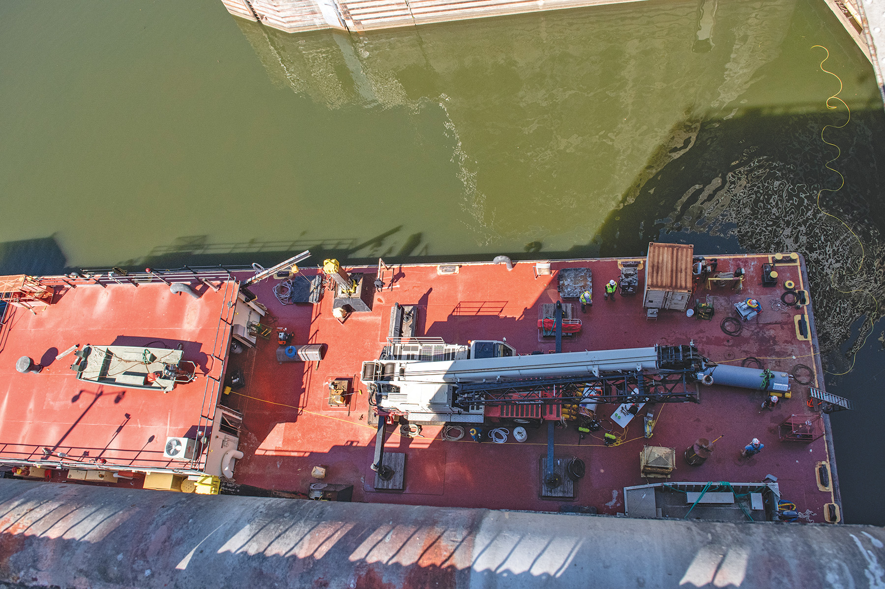 An aerial view of the ND-40, a maintenance barge belonging to the Nashville District, from the top of the main chamber at Wilson Lock. The barge serves as a base of operations for dive-certified district lock mechanics as well as operators of a Remotely-Operated Vehicle (ROV) visiting from the the Corps’ Engineer Research and Development Center (ERDC). The power cable connecting the ROV to the barge is visible in the upper-right corner of the photo. (Photos by Jeremy Croft/Nashville Engineer District)