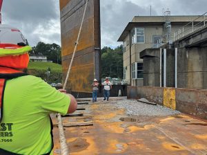 Crews lift a bulkhead into place at Holt Lock on the Black Warrior River near Tuscaloosa, Ala. The bulkhead is part of a temporary fix to address cracks and movement in one of the lock’s monoliths. (Photo by Matthew Cornelison) 